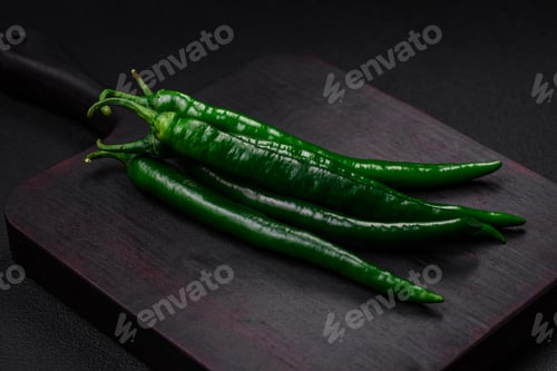 Preview: Fresh hot green chili peppers on a dark concrete background