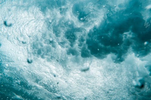 Preview: Underwater View of Wave Crashing to Shore Spraying Drops of Water Across the Sea