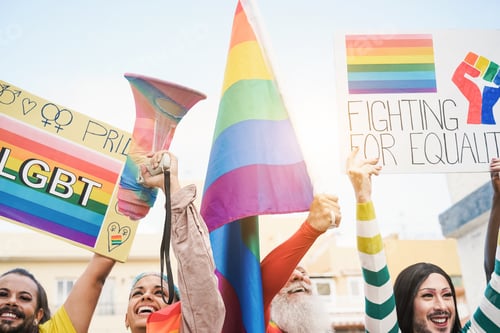 Preview: Gay people holding banners and rainbow flags at lgbt pride event outdoor