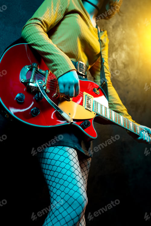 Preview: Close-up photo of young hipster woman legs and red guitar in neon lights.