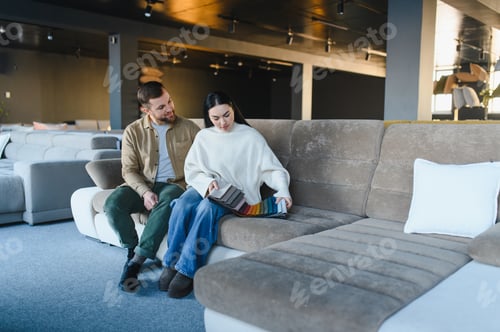 Preview: Couple choosing fabric swatches for new sofa in furniture store