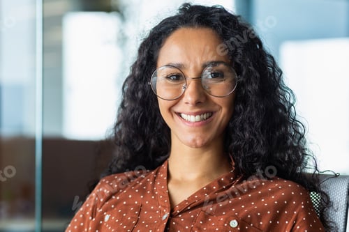 Preview: Close-up portrait of beautiful Latin American businesswoman smiling and looking at camera, working