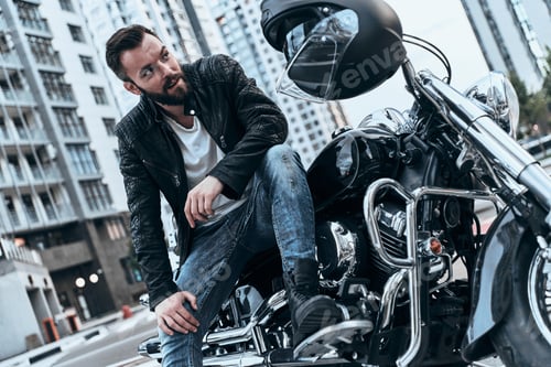 Preview: Enjoying His Lifestyle. Handsome Young Man In Leather Jacket Looking Away While Sitting On The