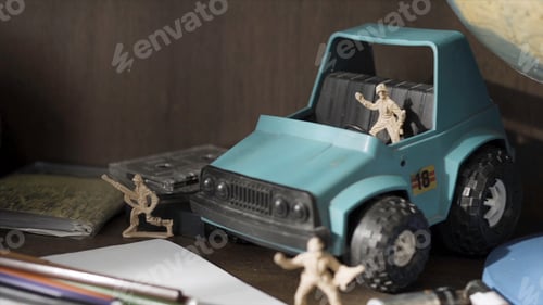 Preview: Toy soldier. Plastic Green Tracked Army Vehicle on a battlefield. Miniature toy soldiers.