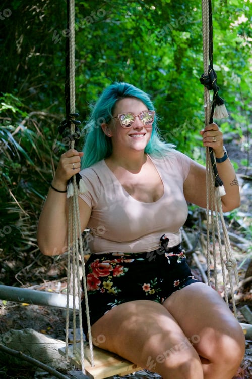 Preview: Fashionable woman sits on a hidden secret swing in a tropical area of La Jolla California