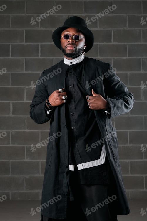 Preview: Serious trendy ethnic man in black outfit and top hat