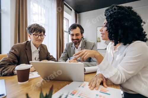 Preview: Business team analyzing financial data on laptop during office meeting
