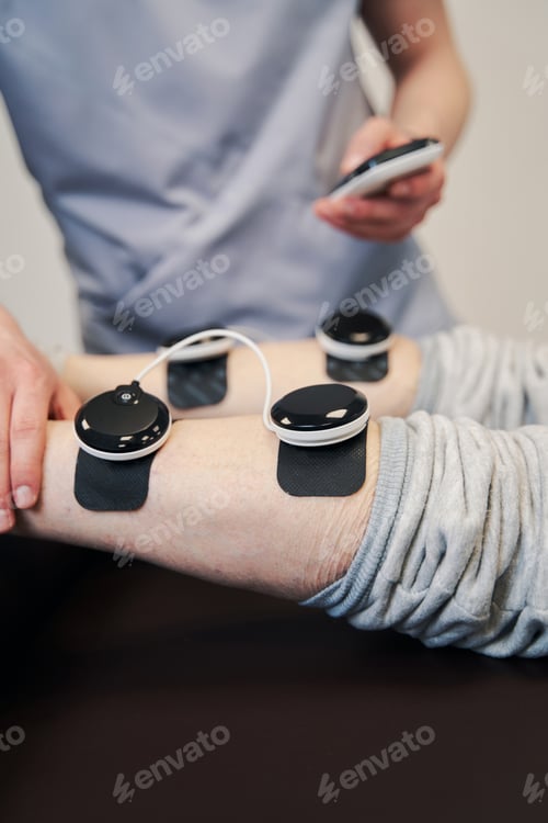 Preview: Medical specialist operating medical device for muscle stimulation