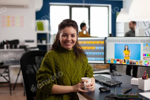 Preview: Woman retoucher looking at camera smiling working in creative media agency