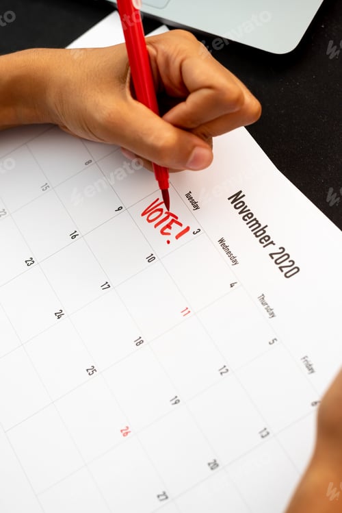 Visualização: Mulher escrevendo em um calendário um lembrete eleitoral do dia da eleição do presidente americano em 2020