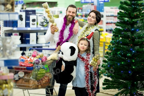 Preview: Happy young family in the supermarket chooses gifts for the new year