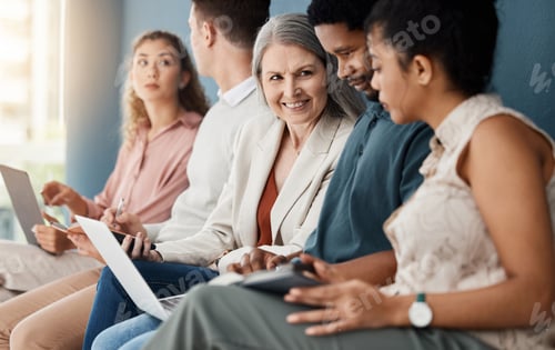 Preview: Group of happy businesspeople sitting on chairs in a row in an office together. Business profession