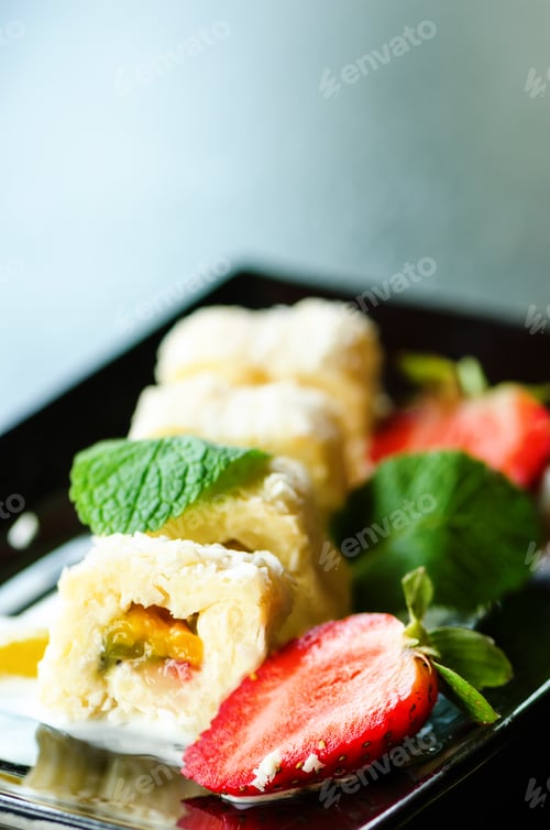 Preview: White sweet roll with kiwi, peaches, strawberries, mint. Serverd with almond peach and chocolate