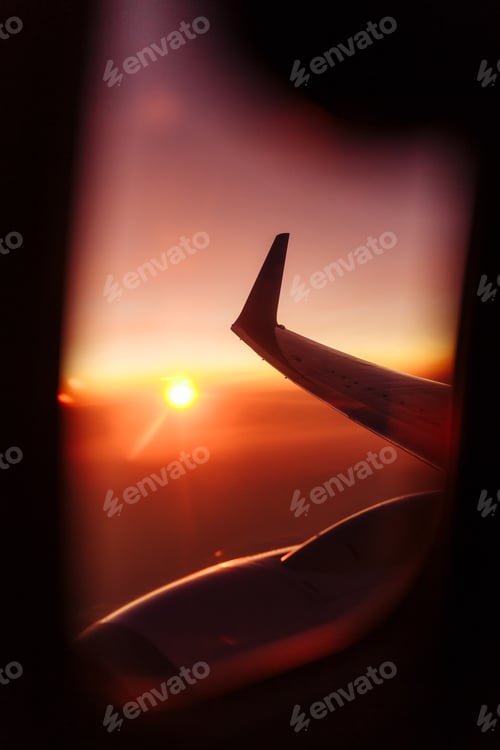 Preview: Beautiful view from airplane window on the wing at sunset or sunrise time. Flying above the clouds.