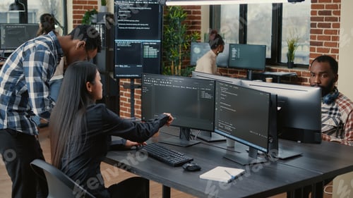 Preview: Mixed team of programmers analyzing source code pointing at screens comparing algorithm