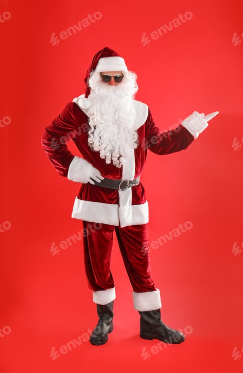 Preview: Full length portrait of Santa Claus with sunglasses on red background