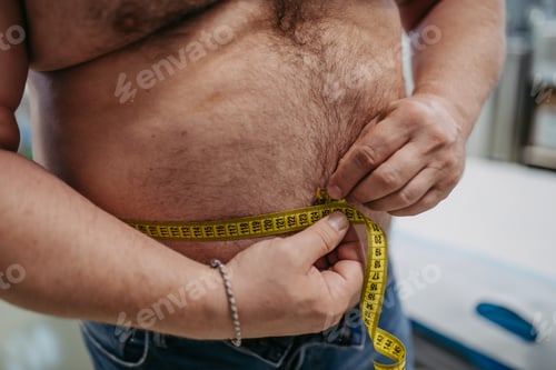 Preview: Close up of overweight man measuring waist, using tape measure. Obesity affecting middle-aged men's