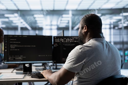 Preview: Engineer typing code on PC to mend data center racks