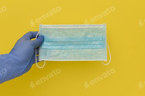 Preview: Protective Face Mask Held in Gloved Hand