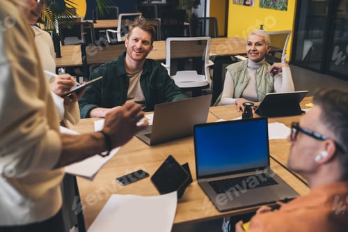 Preview: Cheerful coworkers working on project in workshop