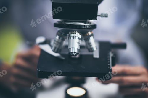 Preview: Young scientist looking through a microscope in a laboratory. Young scientist doing some research.