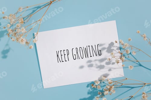 Visualização: Continue cultivando palavras escritas no cartão. Maquete de cartão de convite com gipsófila
em fundo azul.