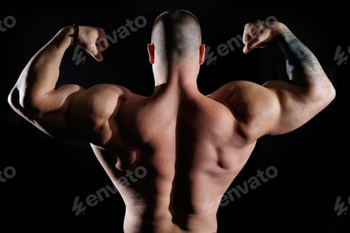 Preview: Muscular man showing muscles, isolated on the black background. Bodybuilder male naked torso abs.