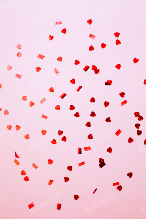 Preview: Red confetti over pink background with copy space for Valentine's Day