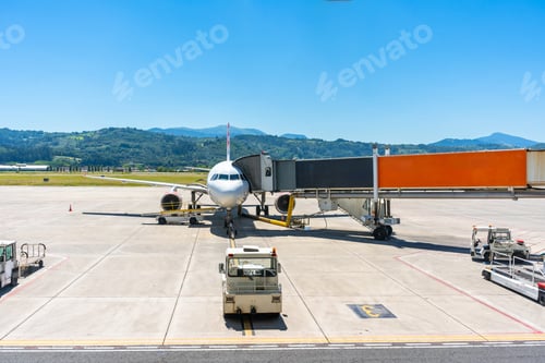 Preview: A white airplane is parked on the tarmac with a large orange gate in front of it