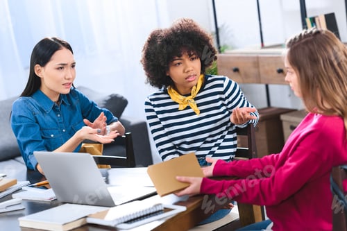 Preview: multiracial students having discussion while doing homework together