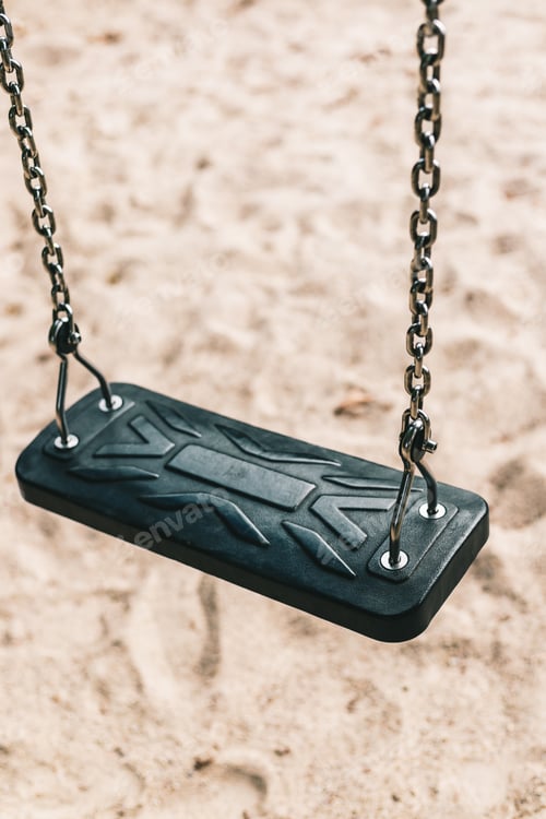 Preview: Close-up vertical image shot of a swing on a background of sand.