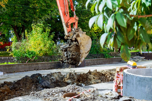 Preview: Excavator with metal tracks unloading soil at construction site during earthmoving works