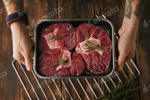 Preview: top view two hands offer meat steaks in pan