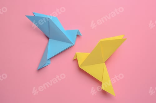 Preview: Beautiful colorful origami birds on pink background, flat lay