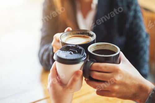 Preview: Closeup image of people enjoyed drinking and clinking coffee cups on the table in cafe