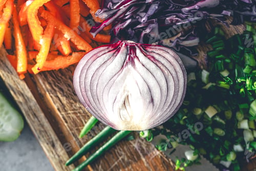 Preview: Close-up, half an onion on a cutting board with fresh vegetables for salad.