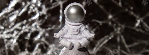 Preview: Plastic toy figure astronaut on silver background Copy space. Concept of out of earth travel