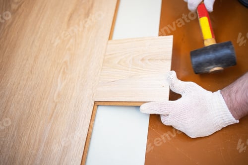 Preview: hammer puts the floorboard in place, professional laying of flooring, laminate