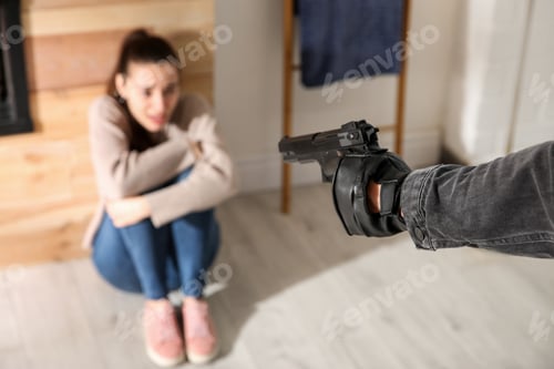Preview: Man aiming his victim with gun indoors, closeup. Dangerous criminal