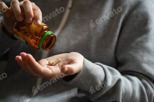 Preview: Person Holding Pill Bottle Pouring Medicine
