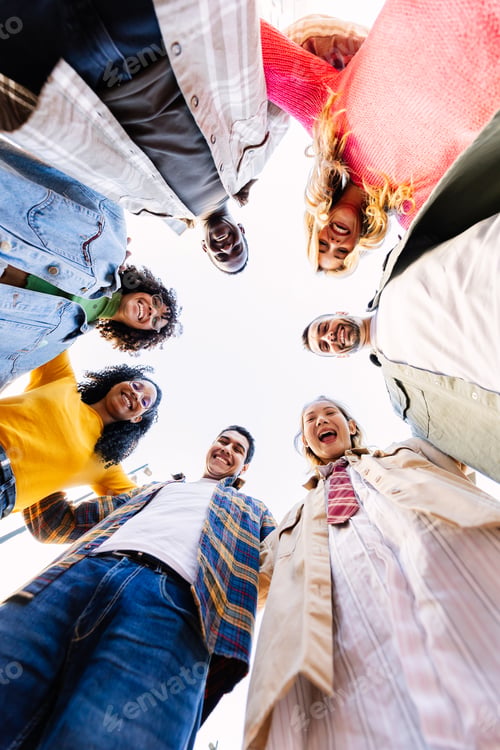 Preview: Smiling portrait of young friends in circle looking at camera