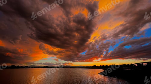 Preview: sunset over a large body of water with an orange sky in the background