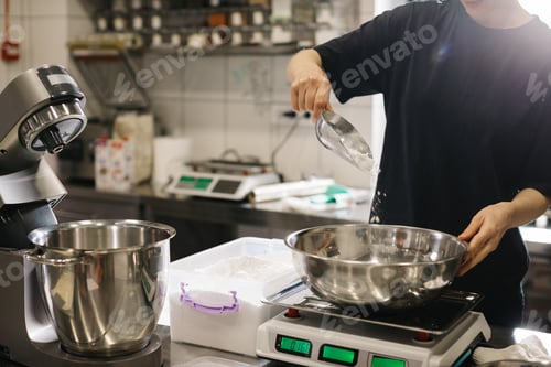 Preview: A woman cook works in a modern industrial kitchen. The process of making cakes in a bakery or cafe.