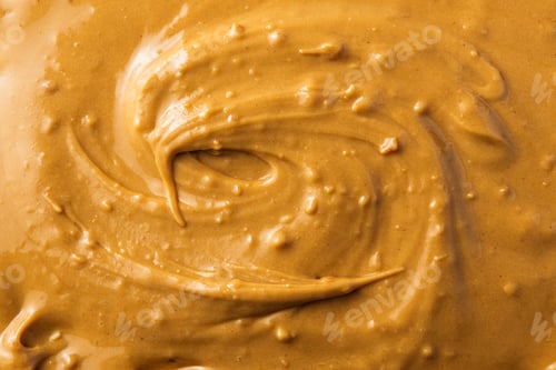 Preview: Creamy peanut butter texture in warm golden tones creates smooth appetizing background