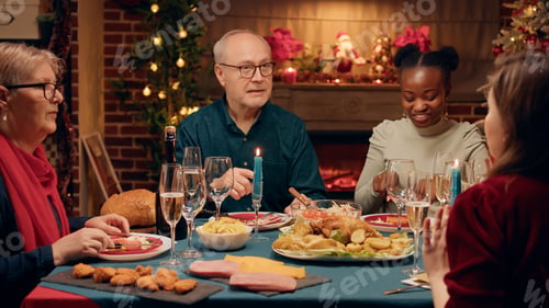 Preview: Senior person talking praising daughter about traditional home cooked food at Christmas dinner table