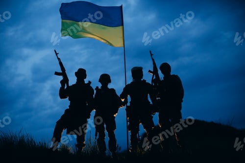 Preview: An evening photo of Ukrainian warriors with their rifles holding a national flag