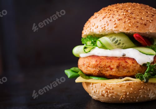 Preview: Big sandwich - hamburger with juicy chicken and tartar sauce on black background
