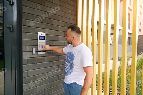 Preview: Man stands at the residential building and dials the code from the intercom door