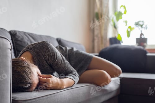 Preview: Pensive woman lying down on sofa