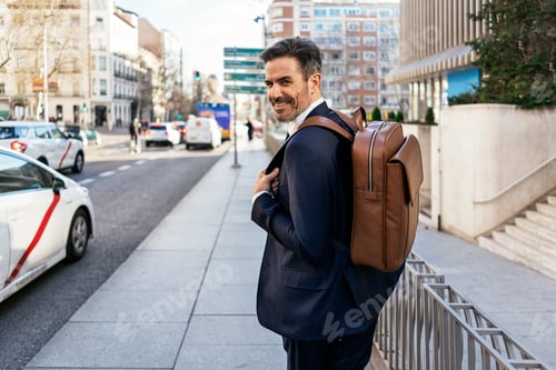 Preview: Businessman with backpack walking in city